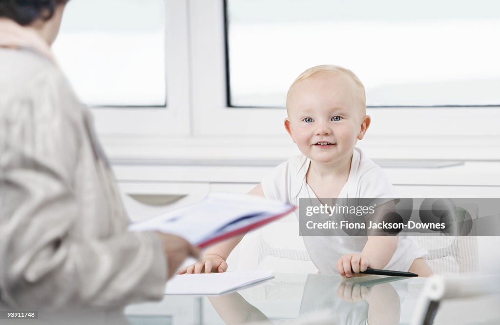 A baby listening to an office colleague