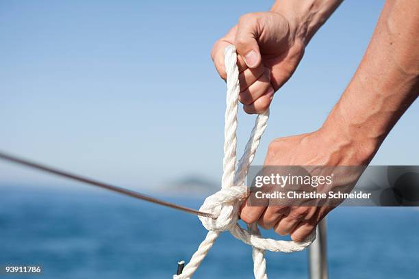 man making knot into rope - desamarrado imagens e fotografias de stock