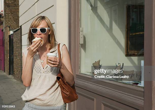 woman eating in street - hackney weekend stock pictures, royalty-free photos & images