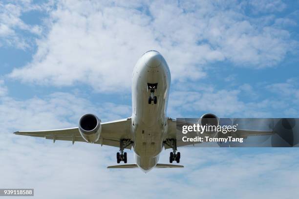 front view of  a landing airplane. - airplane take off stock-fotos und bilder