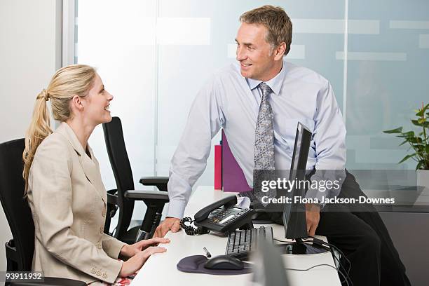a business couple talking - man leaning chair standing side view stock pictures, royalty-free photos & images