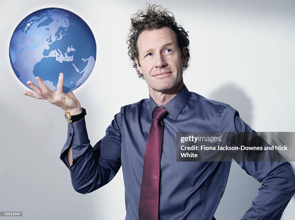 Business man holds up globe