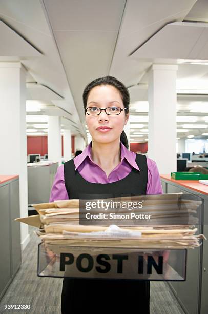 business woman holding a 'post in' tray - overdoing stock pictures, royalty-free photos & images