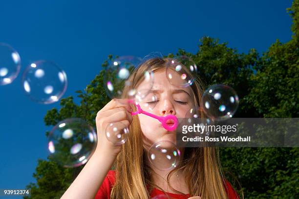 girl blowing bubbles - ross woodhall stock pictures, royalty-free photos & images