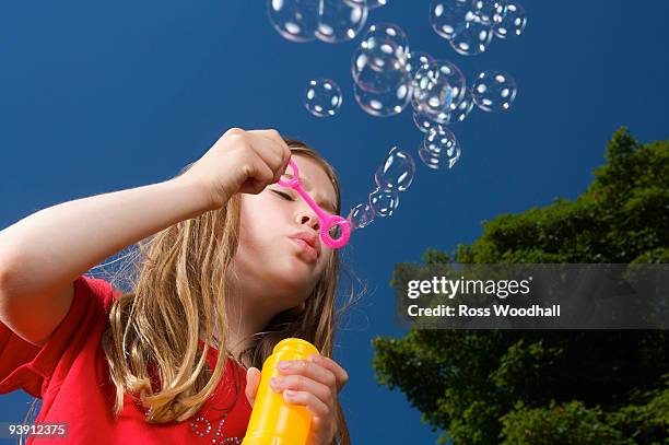 girl blowing bubbles - ross woodhall stock-fotos und bilder