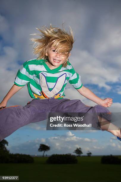 young boy jumping into the air - ross woodhall stock pictures, royalty-free photos & images