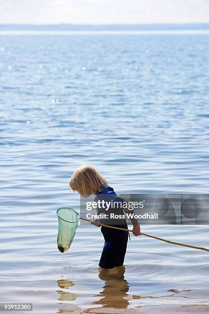 boy look into a fishing net - ross woodhall stock-fotos und bilder