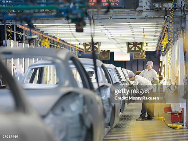 car plant workers on production line - auto industrie stock-fotos und bilder