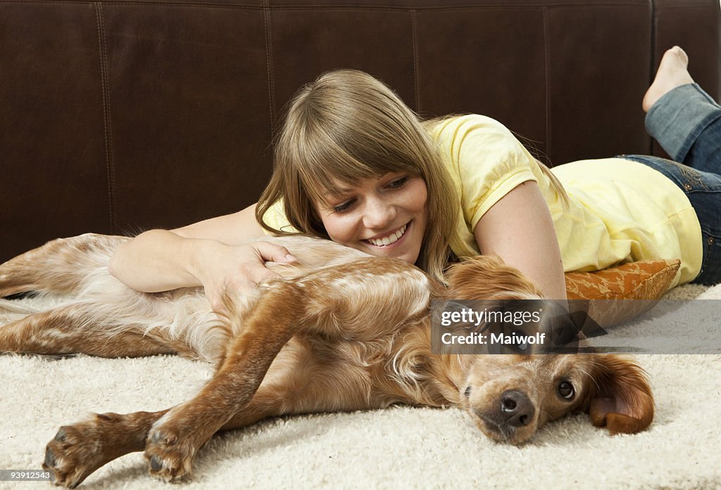 Young woman cuddling with her dog