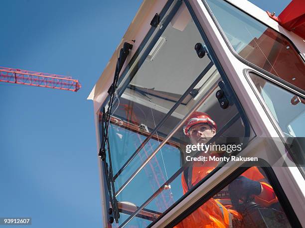 worker controlling crane from cabin - construction equipment operator stock pictures, royalty-free photos & images