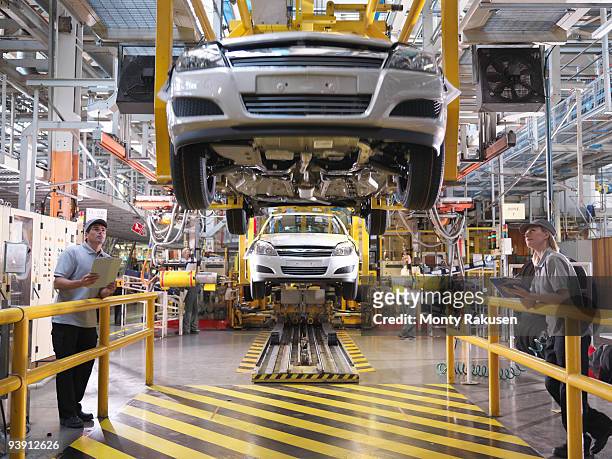 car workers inspecting production line - automobile industry photos et images de collection