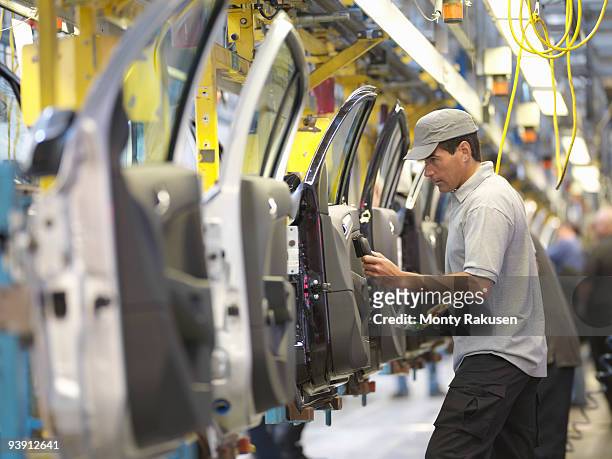 car plant worker on production line - produce fotografías e imágenes de stock