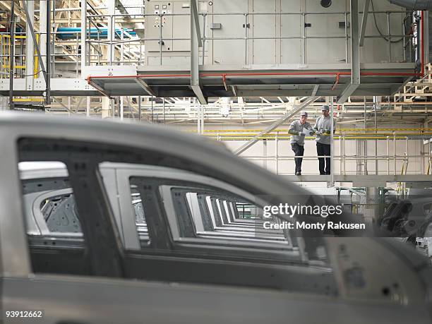 car plant workers observing cars - chassis 個照片及圖片檔