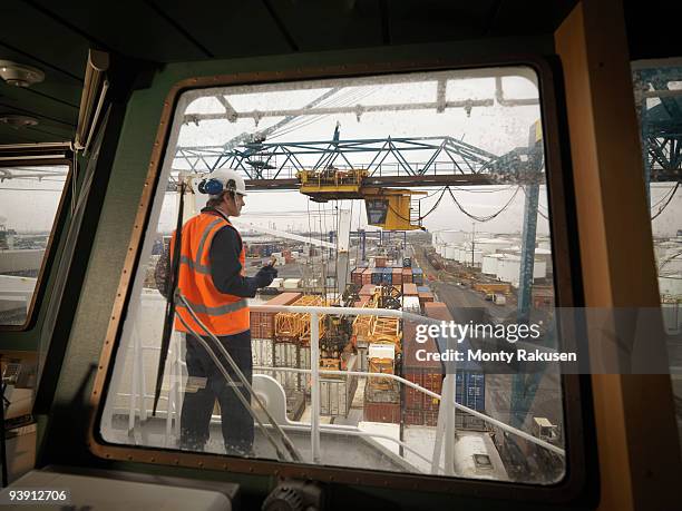 port worker overseeing loading of ship - dock worker stock-fotos und bilder