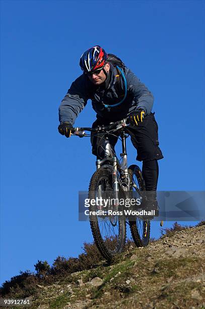 mountain biker riding down a hill. - ross woodhall stock-fotos und bilder