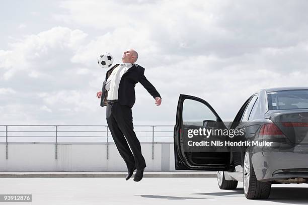 man playing football near car - zusammenprall stock-fotos und bilder