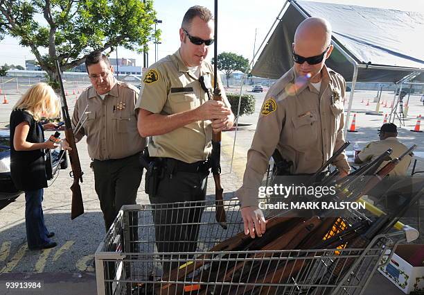 Sheriff's Deputies from the Lennox Station in South Central Los Angeles, add rifles to a stockpile during a "Gun For Gift Card" exchange event on...