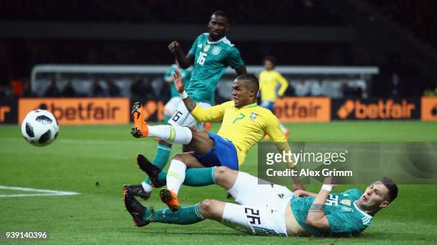 Douglas Costa of Brazil is challenged by Niklas Suele of Germany during the international friendly match between Germany and Brazil at Olympiastadion...
