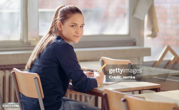 zuversichtlich multi ethnischen teenager studentin im klassenzimmer sitzen - ranking stock-fotos und bilder