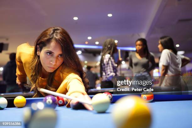 young woman taking shot on pool table - poolbiljart stockfoto's en -beelden