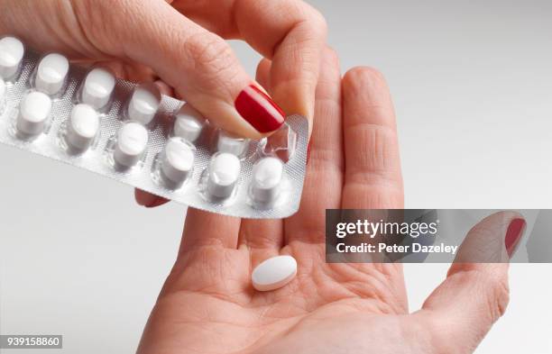 pill being removed from blister pack - medicamentos fotografías e imágenes de stock