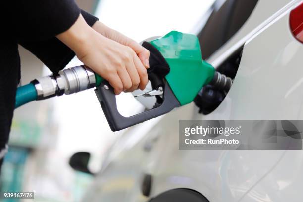 cropped hand of woman refueling car - bensin bildbanksfoton och bilder