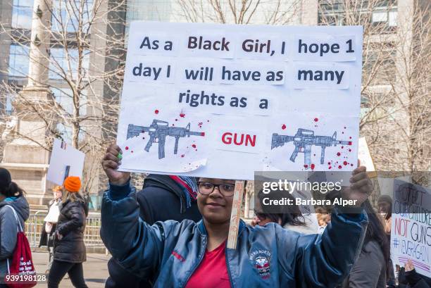 Portrait of demonstrator as she holds a sign that reads 'As a Black Girl, I Hope [One] Day I Will Have as Many Rights as a Gun,' during the March For...