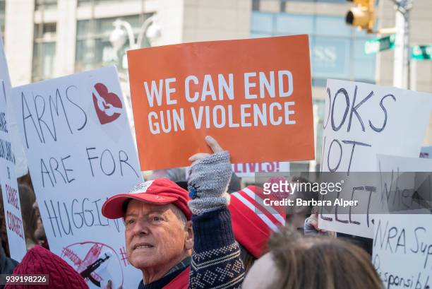View of demonstrators, many with signs, as they participate in the March For Our Lives rally against gun violence, near Columbus Circle, New York,...