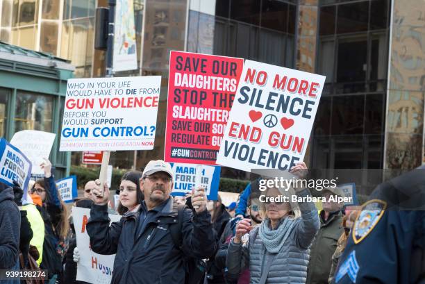 View of demonstrators, many with signs, as they participate in the March For Our Lives rally against gun violence, near Columbus Circle, New York,...