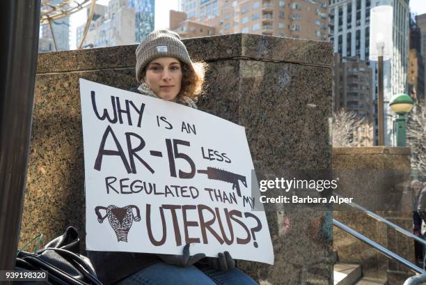 Portrait of demonstrator as she holds a sign that reads 'Why is an A-15 Less Regulated than My Uterus,' during the March For Our Lives rally against...