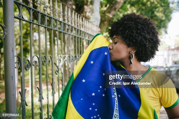 young proud kissing the brazilian flag - brazilian flag stock pictures, royalty-free photos & images