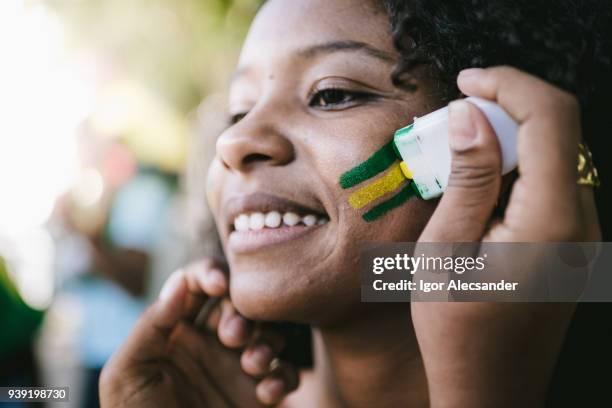 fan van de braziliaanse jonge vrouw die samen met de kleuren van brazilië - a brazil supporter stockfoto's en -beelden