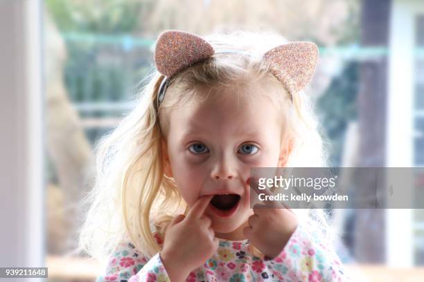 young girl child pulling funny face - kelly bowden stockfoto's en -beelden
