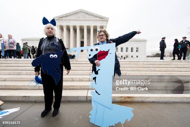 Gerrymandering activists Helenmary Ball, left, posing as MD district 5, and Rachael Lemberg, posing as MD district 1, gather on the steps of the...