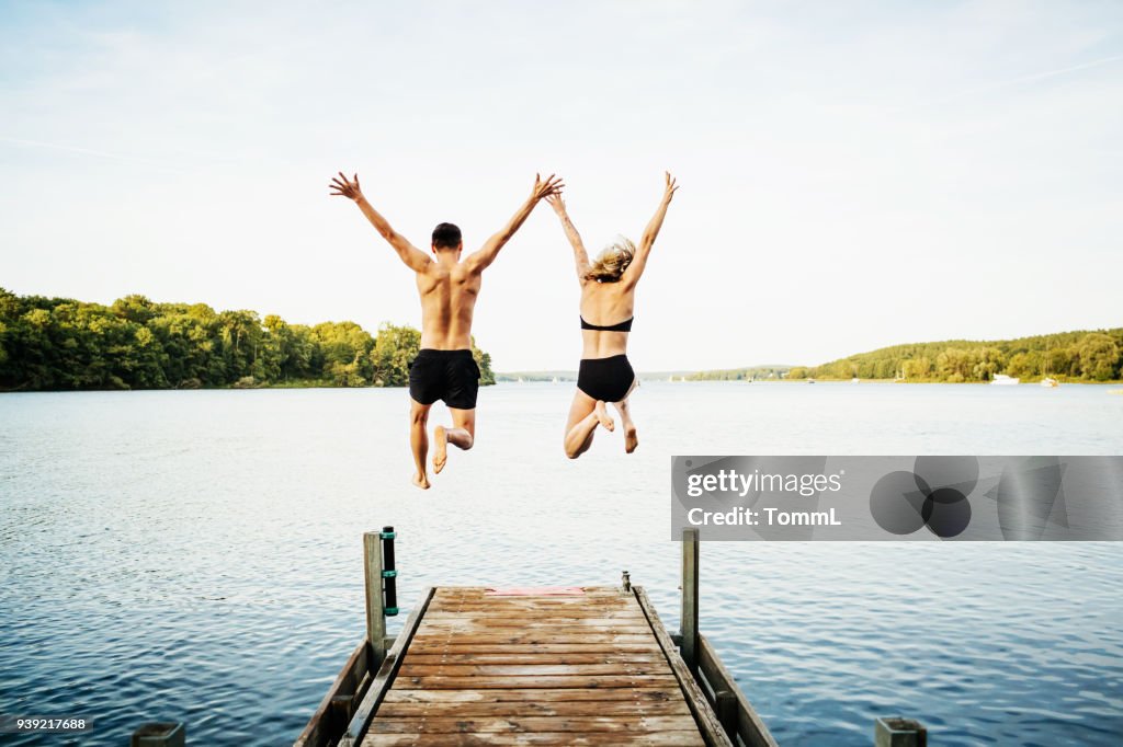 Twee vrienden samen springen van Jetty op Lake