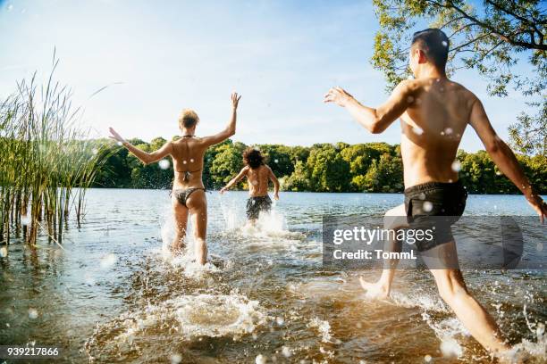 gruppieren von freunden eifrig laufen in see - berlin ufer stock-fotos und bilder