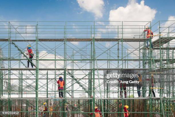 construction worker on scaffolding in construction site - scaffolding stock pictures, royalty-free photos & images