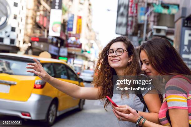 friends traveling abroad to asia waiting for a taxi on the street - ximen stock pictures, royalty-free photos & images