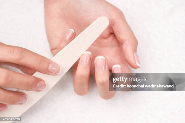 woman hands in a nail salon receiving a manicure. - nail file stock pictures, royalty-free photos & images