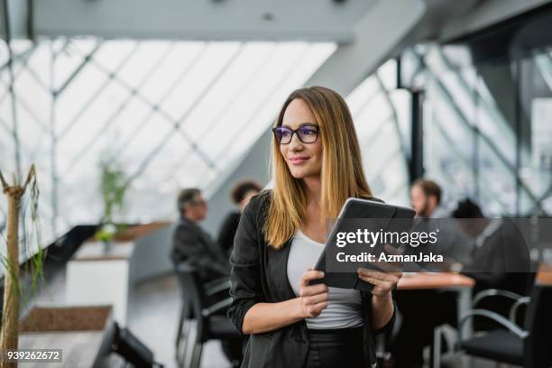 portrait of a businesswoman holding a digital tablet - business casual clothing stock pictures, royalty-free photos & images