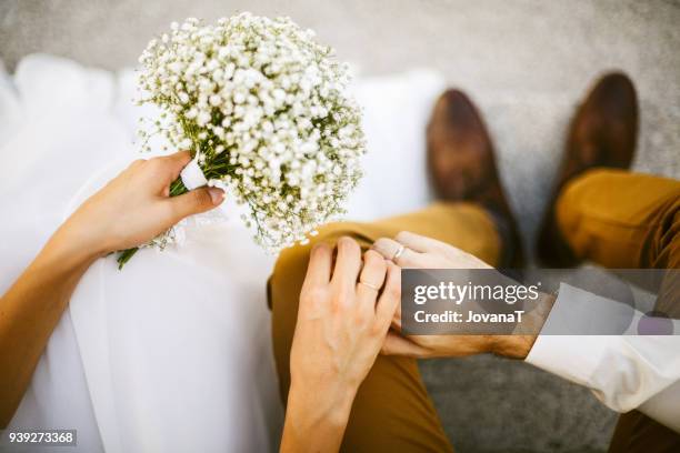 bride and groom holding their hands together - mariage stock-fotos und bilder