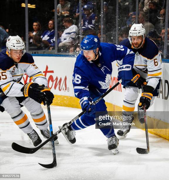 Mitchell Marner of the Toronto Maple Leafs skates Rasmus Ristolainen and Marco Scandella of the Buffalo Sabres during the first period at the Air...