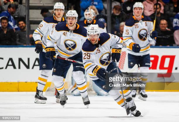 Jason Pominville and Justin Falk of the Buffalo Sabres skate against the Toronto Maple Leafs during the second period at the Air Canada Centre on...
