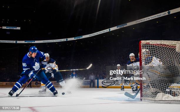 Roman Polak of the Toronto Maple Leafs battles for the puck with Zemgus Girgensons of the Buffalo Sabres during the third period at the Air Canada...