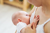 Young mom breast feeding her newborn child. Lactation infant concept. Mother feed her baby son or daughter with breast milk