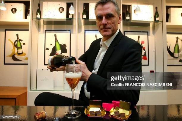 Pascal Prudhomme, general director of the Champagne Castelnau group poses on March 22, 2018 in Reims with a bottle of rose Champagne and chocolates...