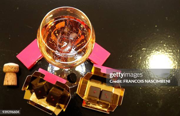 Picture taken on March 22, 2018 in Reims shows a bottle of rose Champagne of Castelnau and chocolates with Espelette pepper made by master...