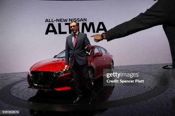 Photographers point as Denis Le Vot, the new chairman of Nissan North America, walks beside the 2019 Nissan Altima sedan at the New York...