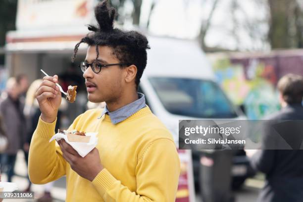 junger mann straße essen beim festival - falafel stock-fotos und bilder