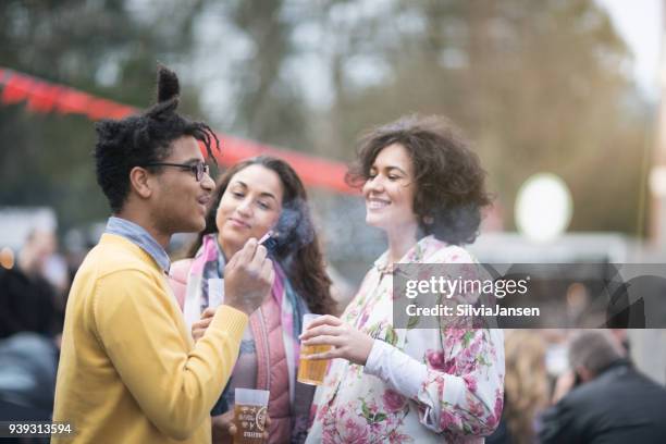 festival: freunden zusammen einen drink und eine zigarette rauchen - drinking beer festival stock-fotos und bilder